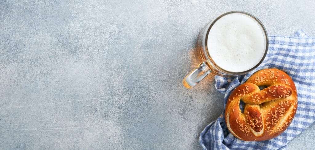 Bavarian pretzels and glass of lager beer. Oktoberfest food menu, traditional salted pretzels on lig